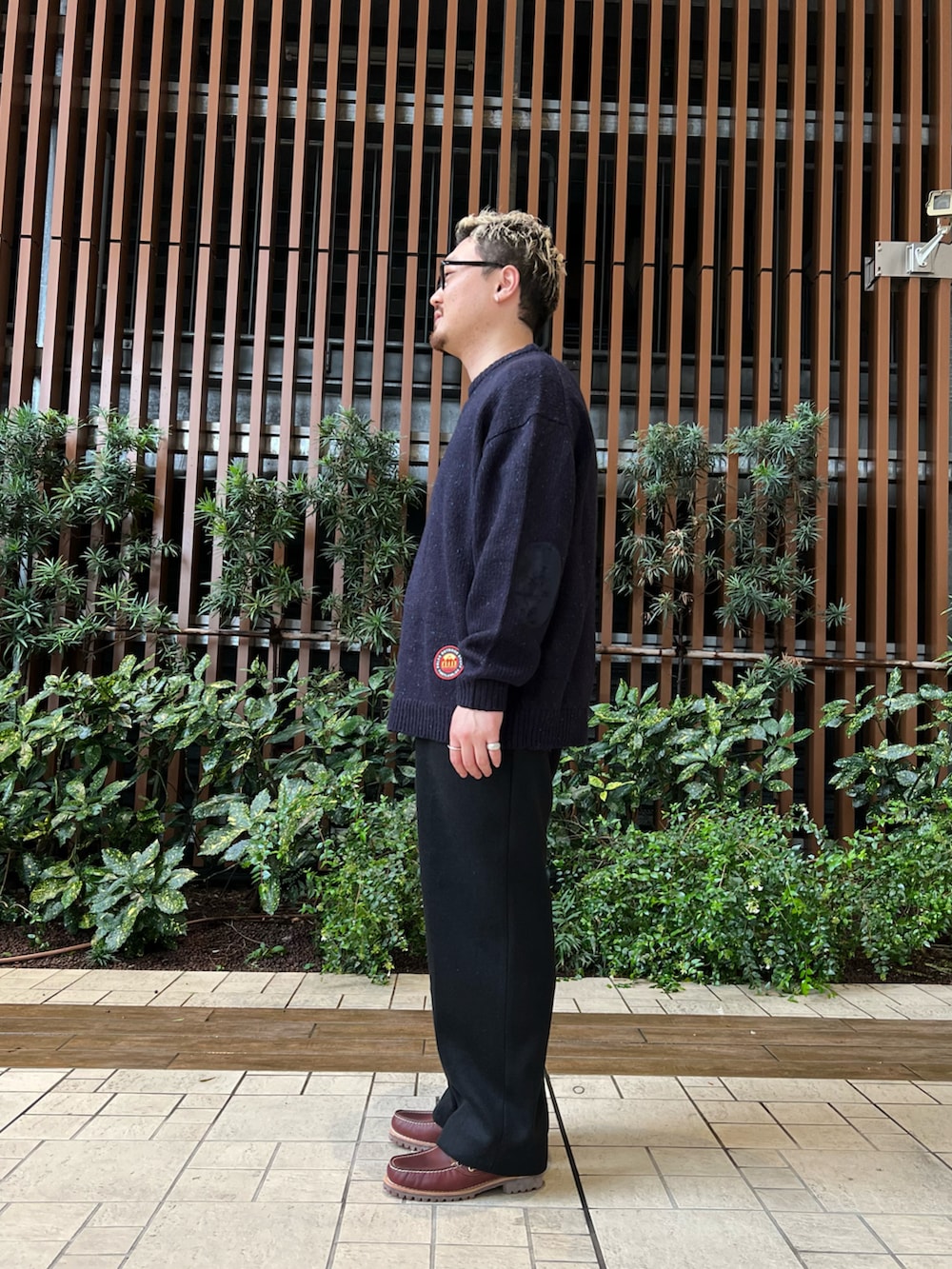 ブルー系のニット/セーター、ブラック系のその他パンツ、レッド系のモカシン/デッキシューズを着用したメンズの秋コーディネートの2枚目の写真