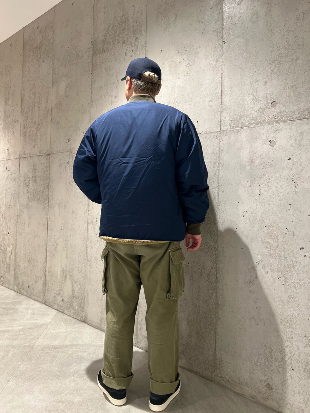 グリーン系のカーゴパンツ、ブルー系のブルゾン、グレー系のスウェットを着用したメンズの秋コーディネートの5枚目の写真