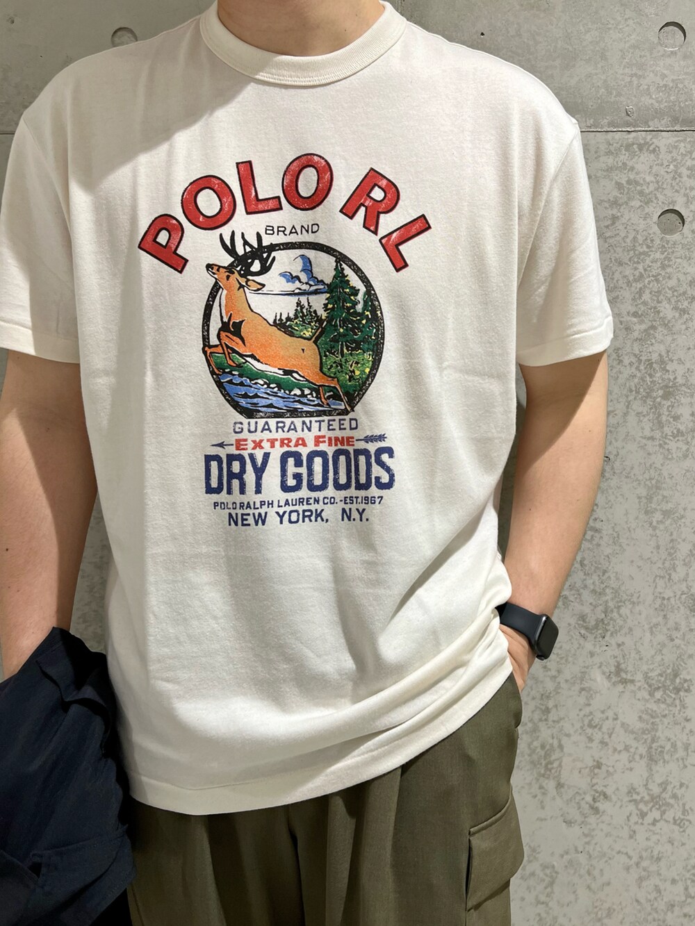 ブラック系のシャツ/ブラウス、ホワイト系のスニーカー、グリーン系のカーゴパンツを着用したメンズの夏コーディネートの3枚目の写真