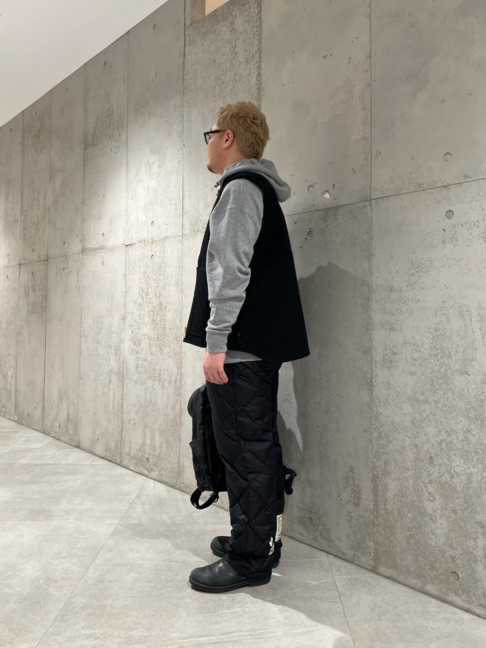 グレー系のパーカー、ブラック系のその他パンツ、ブラック系のバックパック/リュックを着用したメンズの冬コーディネートの2枚目の写真