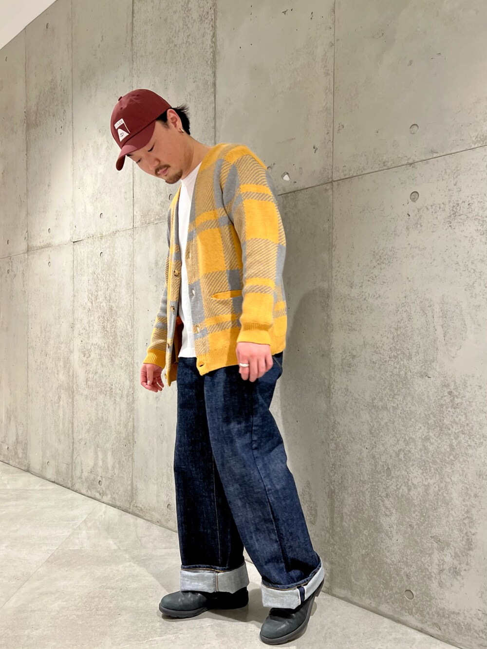 イエロー系のカーディガン/ボレロ、ブルー系のデニムパンツ、ブラック系のスニーカーを着用したメンズの冬コーディネートの3枚目の写真