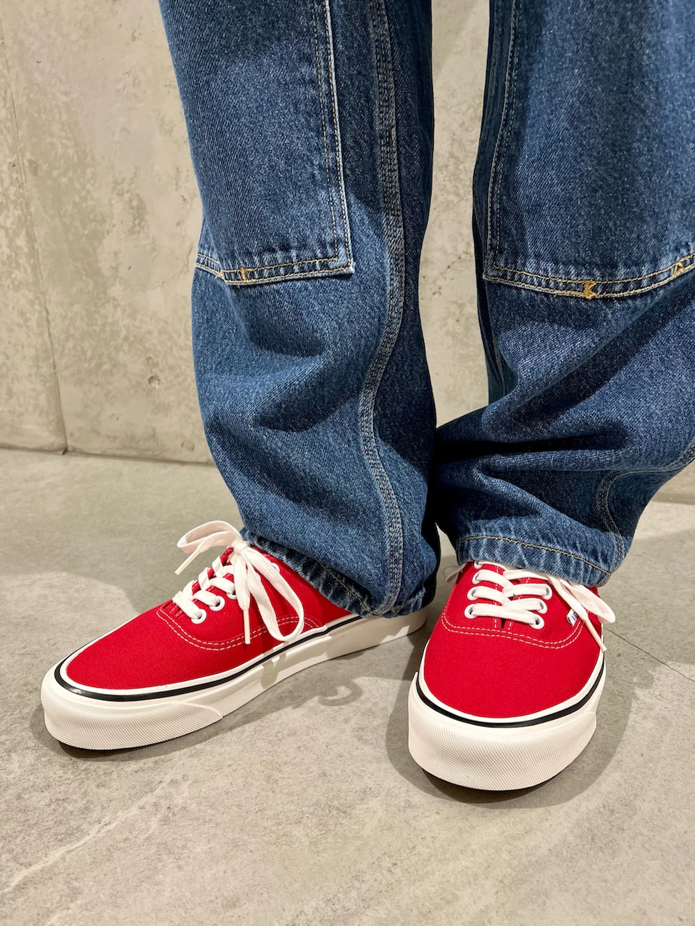 レッド系のスニーカー、ベージュ系のシャツ/ブラウス、ホワイト系のTシャツ/カットソーを着用したメンズの春コーディネートの2枚目の写真