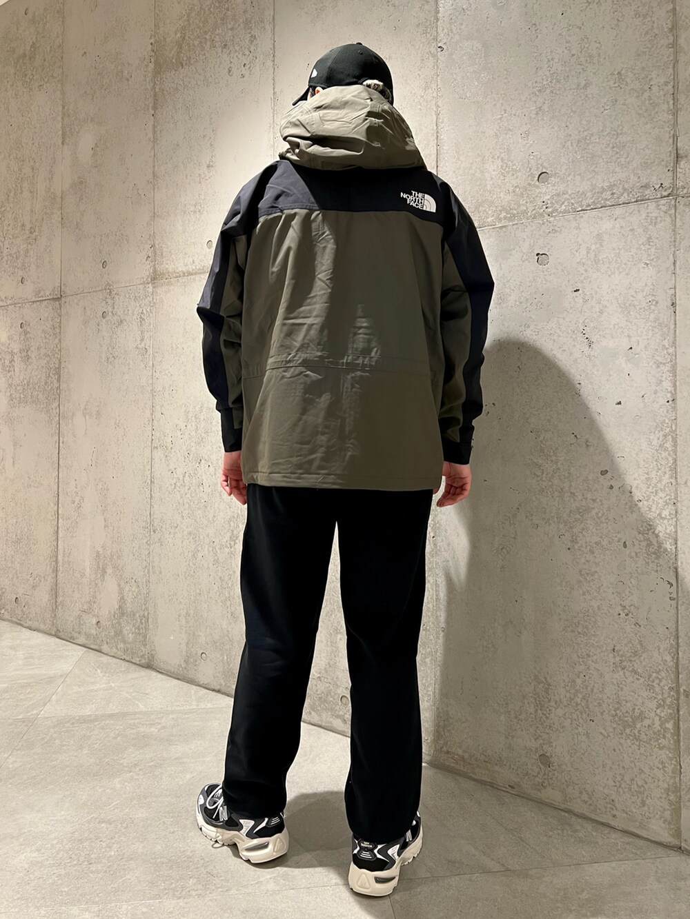 グリーン系のナイロンジャケット、ブラック系のスニーカー、ブラック系のスウェットパンツを着用したメンズの春コーディネートの4枚目の写真