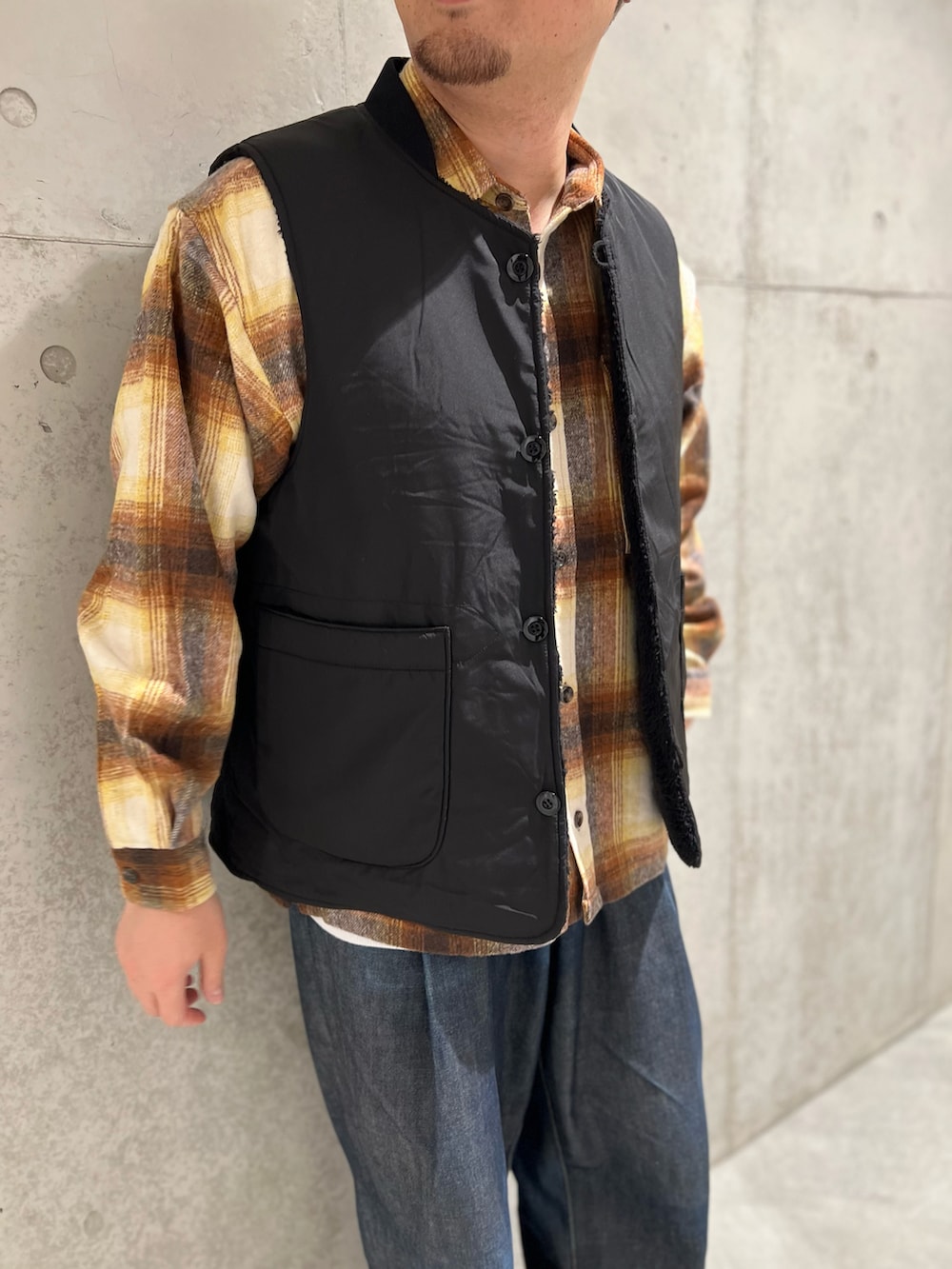 ブラック系のその他アウター、ブルー系のデニムパンツ、レッド系のモカシン/デッキシューズを着用したメンズの秋コーディネートの4枚目の写真