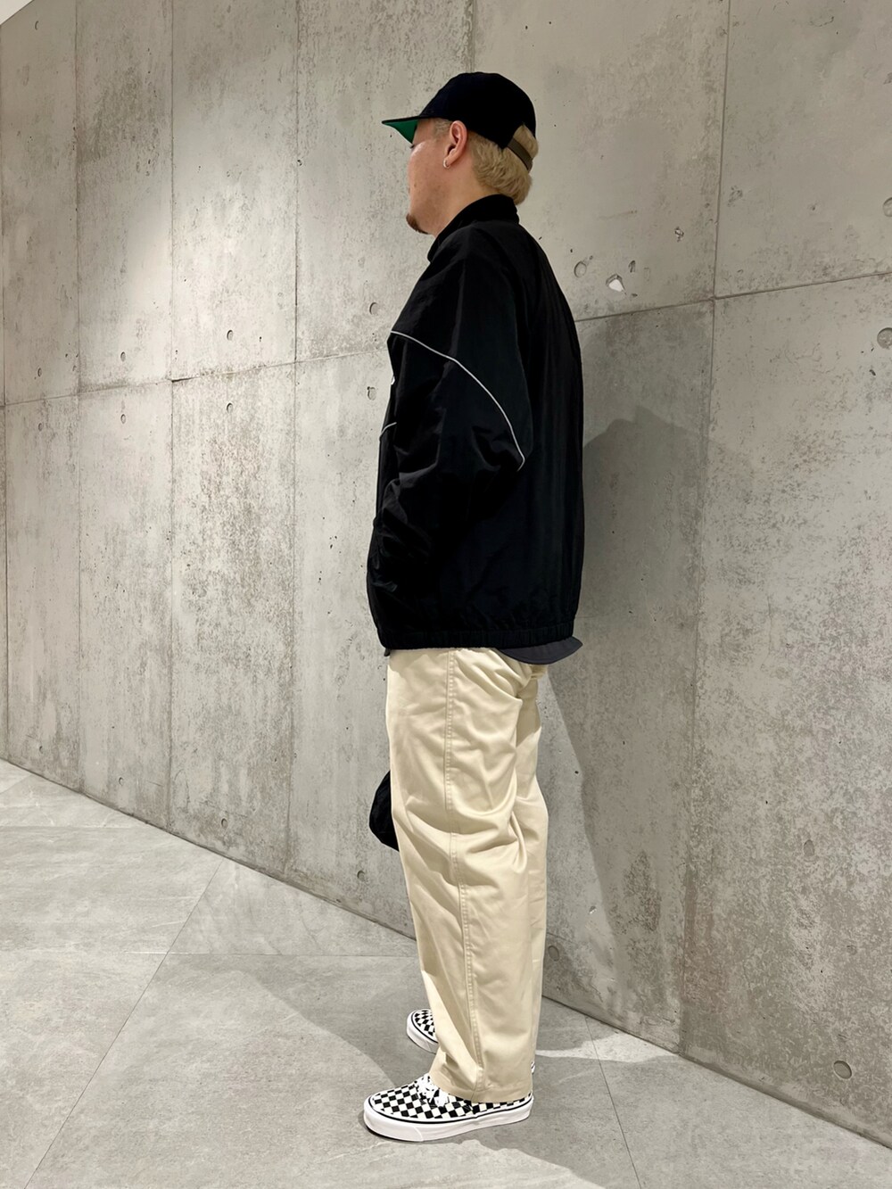 ブラック系のブルゾン、グレー系のTシャツ/カットソー、ホワイト系のチノパンツを着用したメンズの秋コーディネートの2枚目の写真