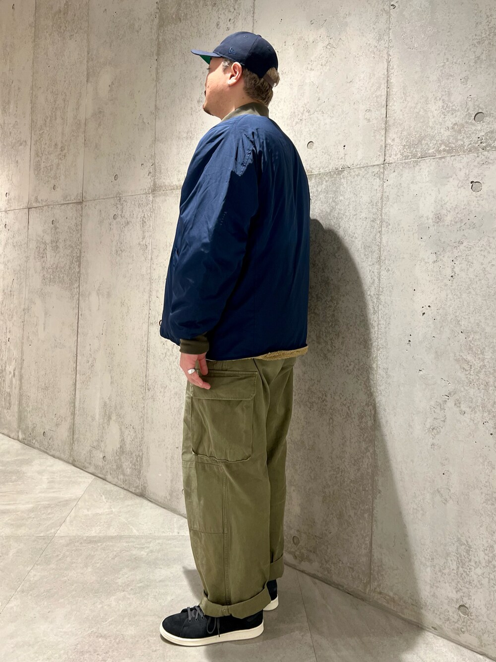 グリーン系のカーゴパンツ、ブルー系のブルゾン、グレー系のスウェットを着用したメンズの秋コーディネートの4枚目の写真