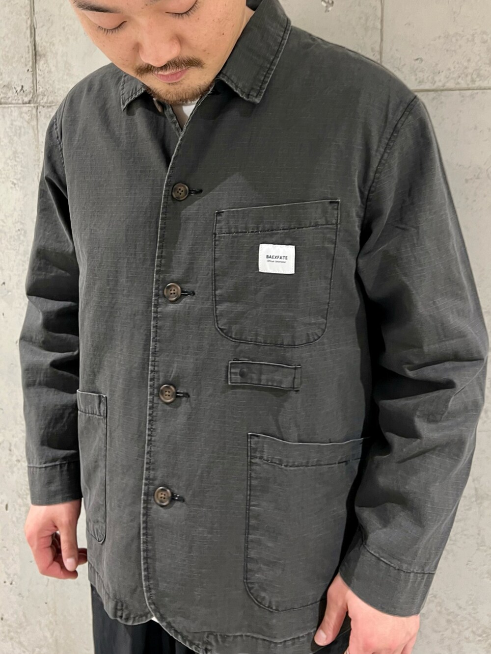 ブラック系のカバーオール、ホワイト系のTシャツ/カットソー、ブラック系のブーツを着用したメンズの春コーディネートの2枚目の写真