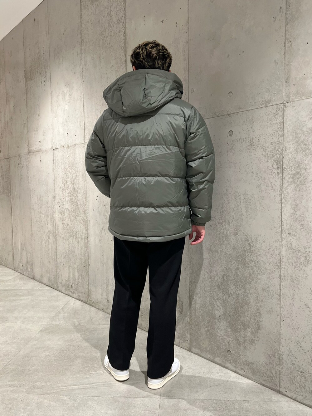 グリーン系のダウンジャケット/コート、ホワイト系のスニーカー、ブラック系のその他パンツを着用したメンズの冬コーディネートの4枚目の写真