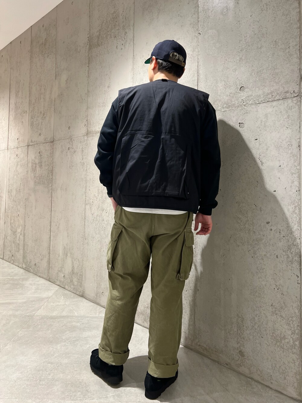ブラック系のベスト、グリーン系のカーゴパンツ、ブラック系のブーツを着用したメンズの冬コーディネートの5枚目の写真