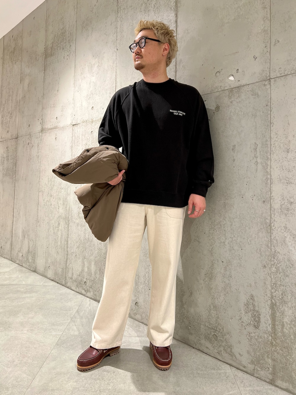 ブラウン系のダウンジャケット/コート、レッド系のモカシン/デッキシューズ、ホワイト系のデニムパンツを着用したメンズの秋コーディネートの2枚目の写真