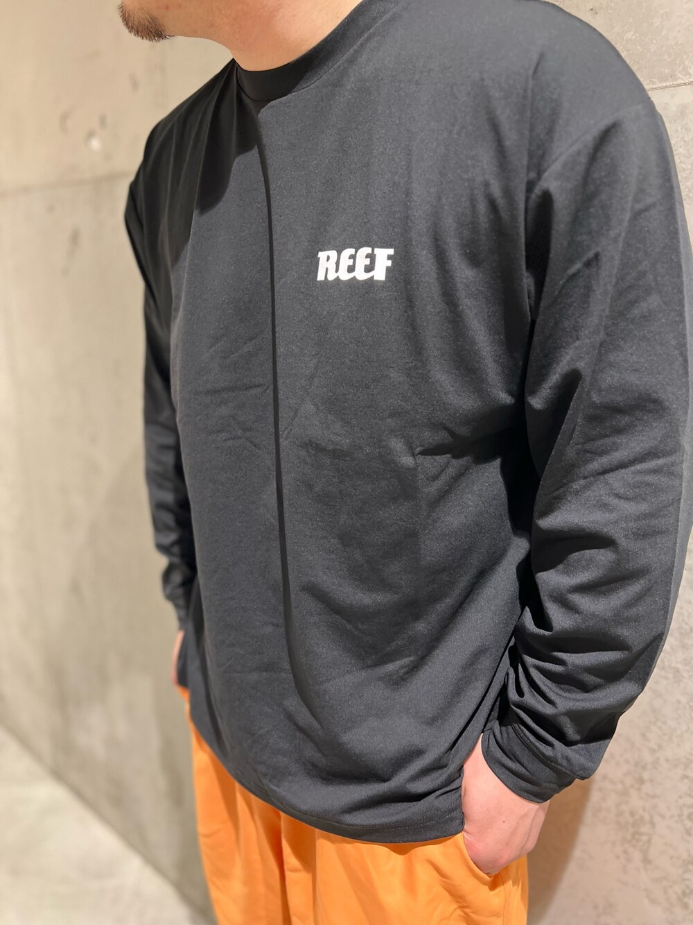 ブラック系のTシャツ/カットソー、オレンジ系のその他パンツ、ブラック系のサンダルを着用したメンズの夏コーディネートの4枚目の写真