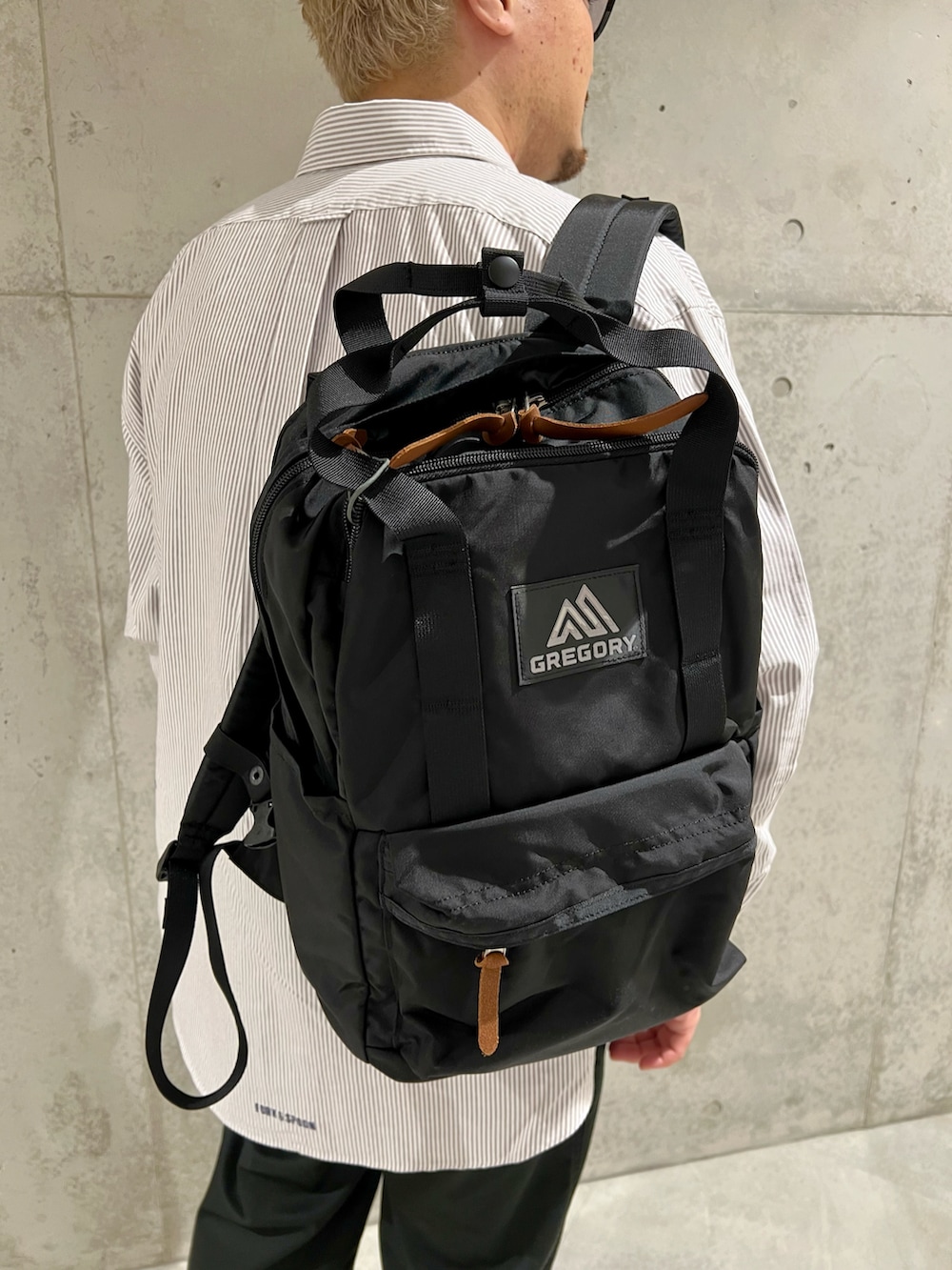 ブラウン系のシャツ/ブラウス、ブラック系のバックパック/リュック、ブラック系のチノパンツを着用したメンズの秋コーディネートの4枚目の写真