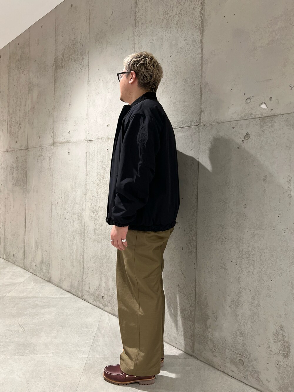 グリーン系のその他パンツ、レッド系のモカシン/デッキシューズ、ホワイト系のTシャツ/カットソーを着用したメンズの秋コーディネートの2枚目の写真