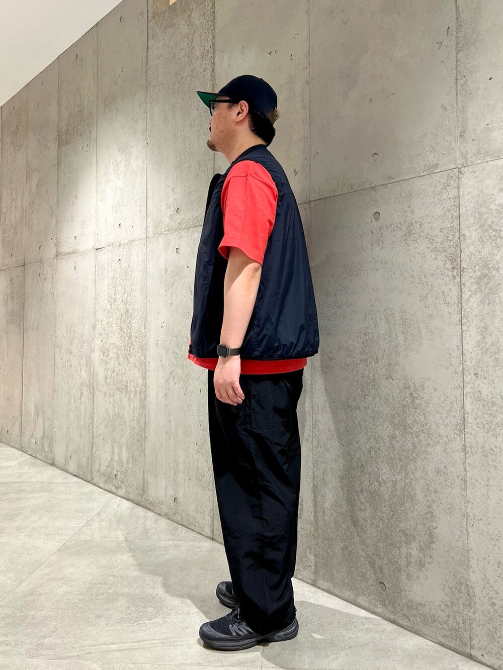 レッド系のTシャツ/カットソー、ブラック系のベスト、ブラック系のその他パンツを着用したメンズの春コーディネートの2枚目の写真