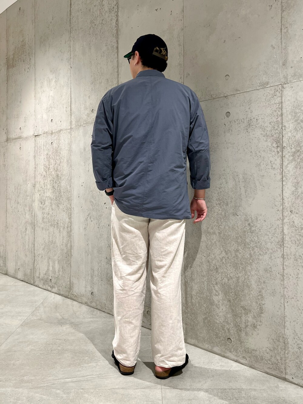 ホワイト系のTシャツ/カットソー、ブラック系のサンダル、グレー系のその他アウターを着用したメンズの秋コーディネートの4枚目の写真