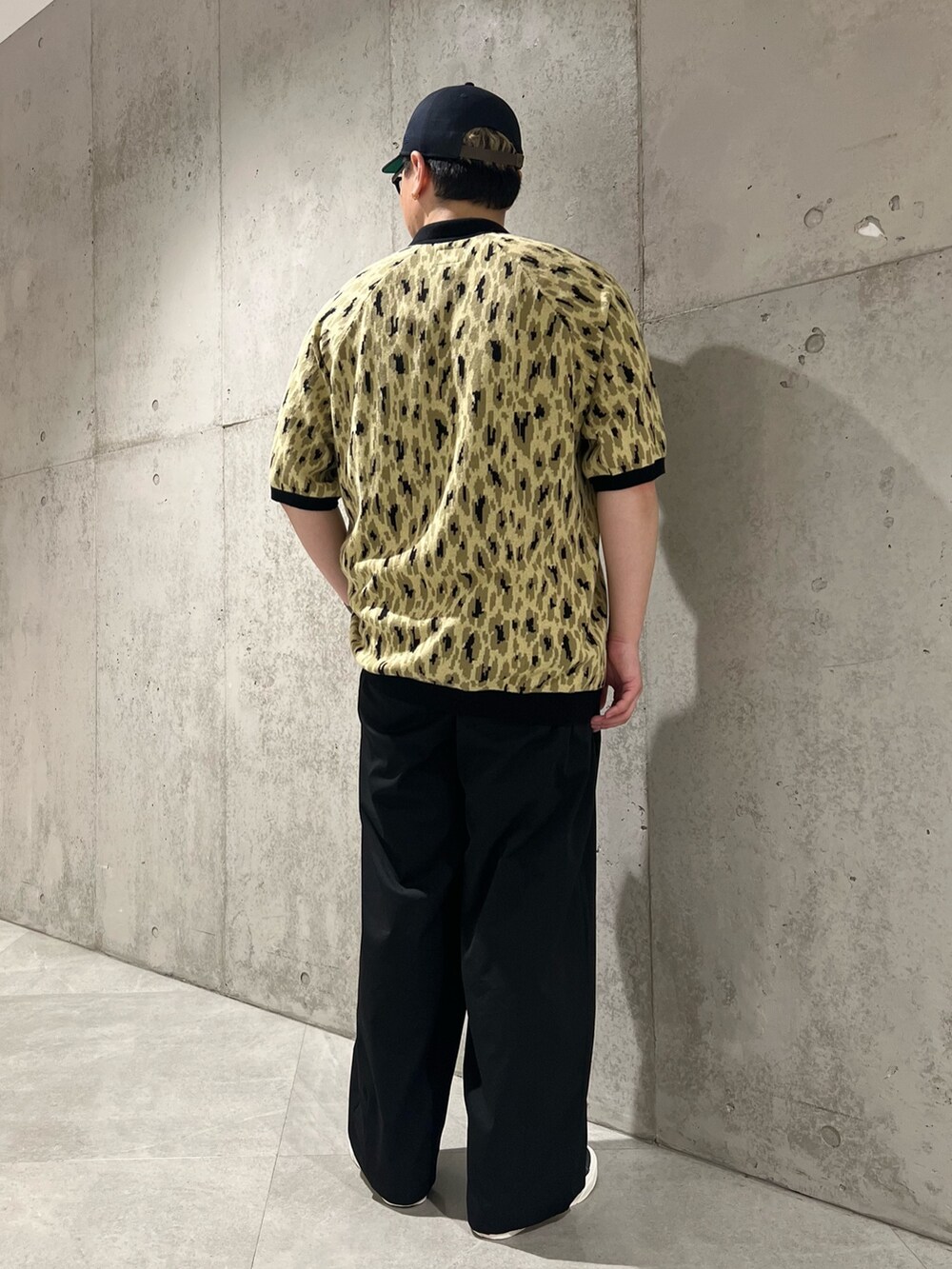 グリーン系のポロシャツ、ブラック系のその他パンツ、ブラック系のスニーカーを着用したメンズの春コーディネートの3枚目の写真