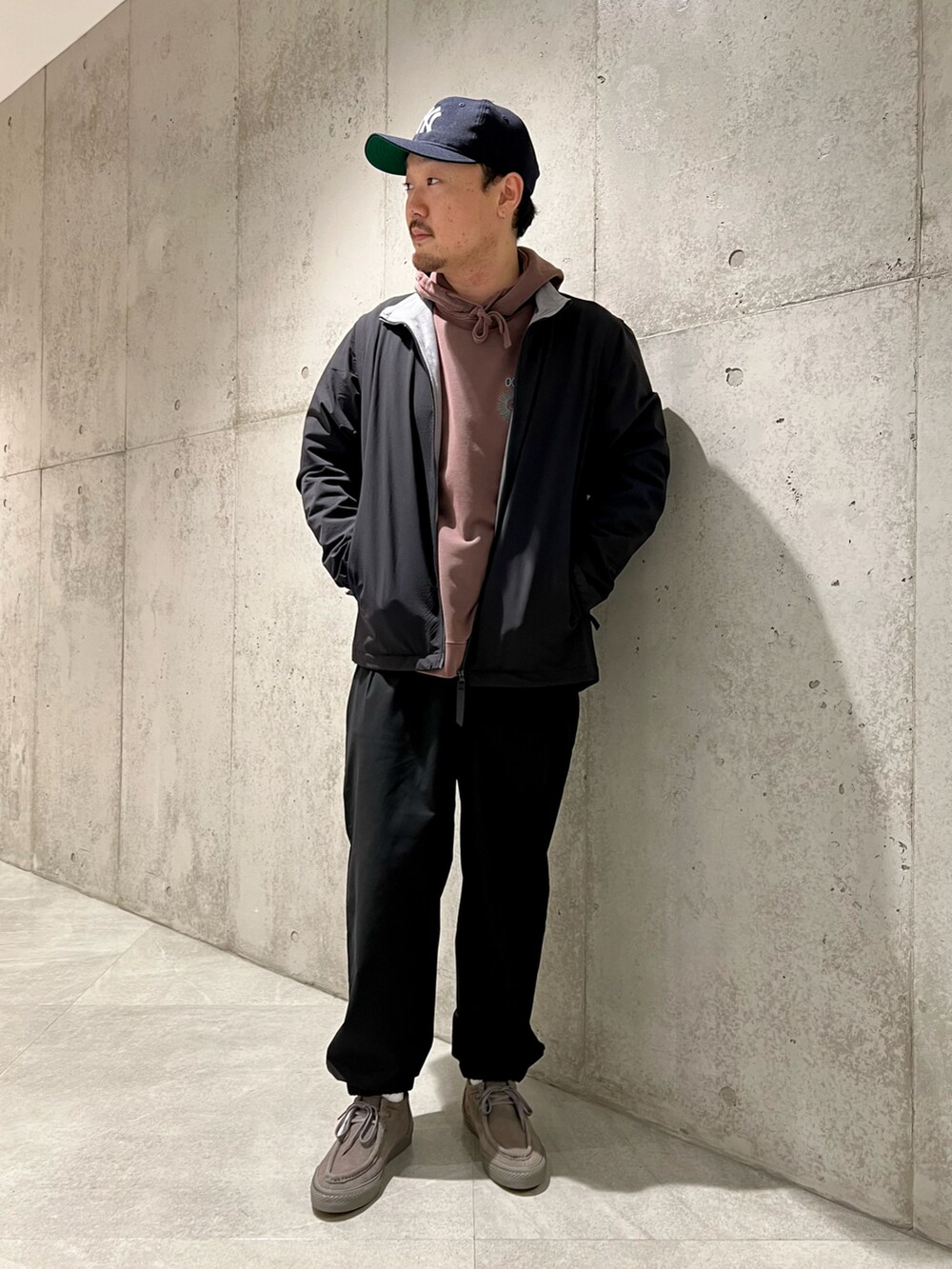 ブラック系のブルゾン、レッド系のパーカー、ブラック系のその他パンツを着用したメンズの冬コーディネートの4枚目の写真