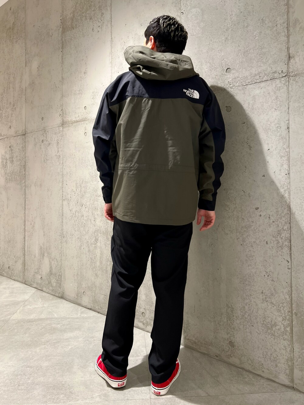 グリーン系のナイロンジャケット、ブラック系のTシャツ/カットソー、ブラック系のその他パンツを着用したメンズの春コーディネートの4枚目の写真