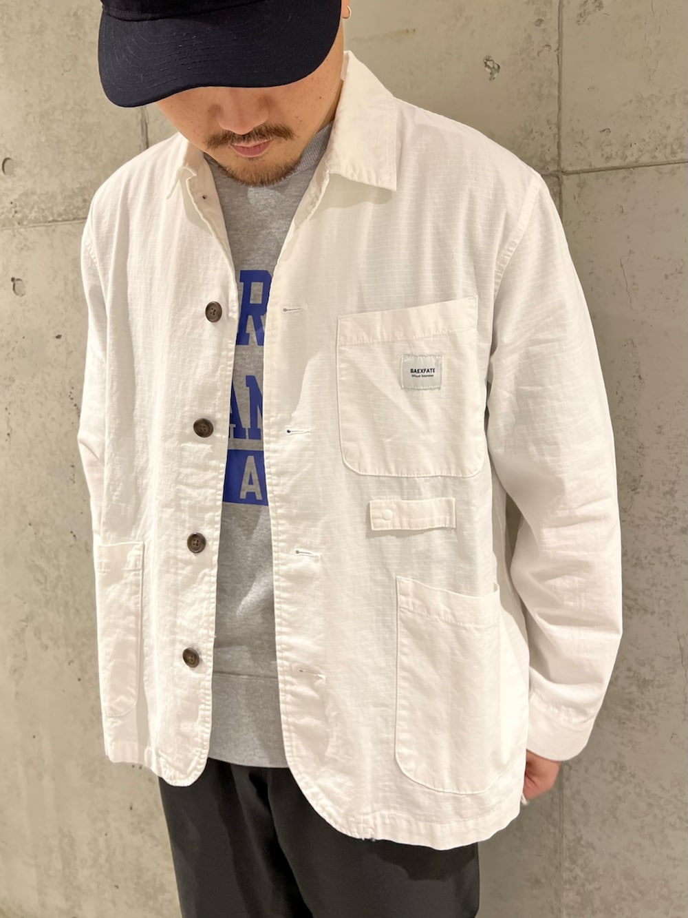 ホワイト系のカバーオール、ブラック系のその他パンツ、グレー系のTシャツ/カットソーを着用したメンズの春コーディネートの2枚目の写真