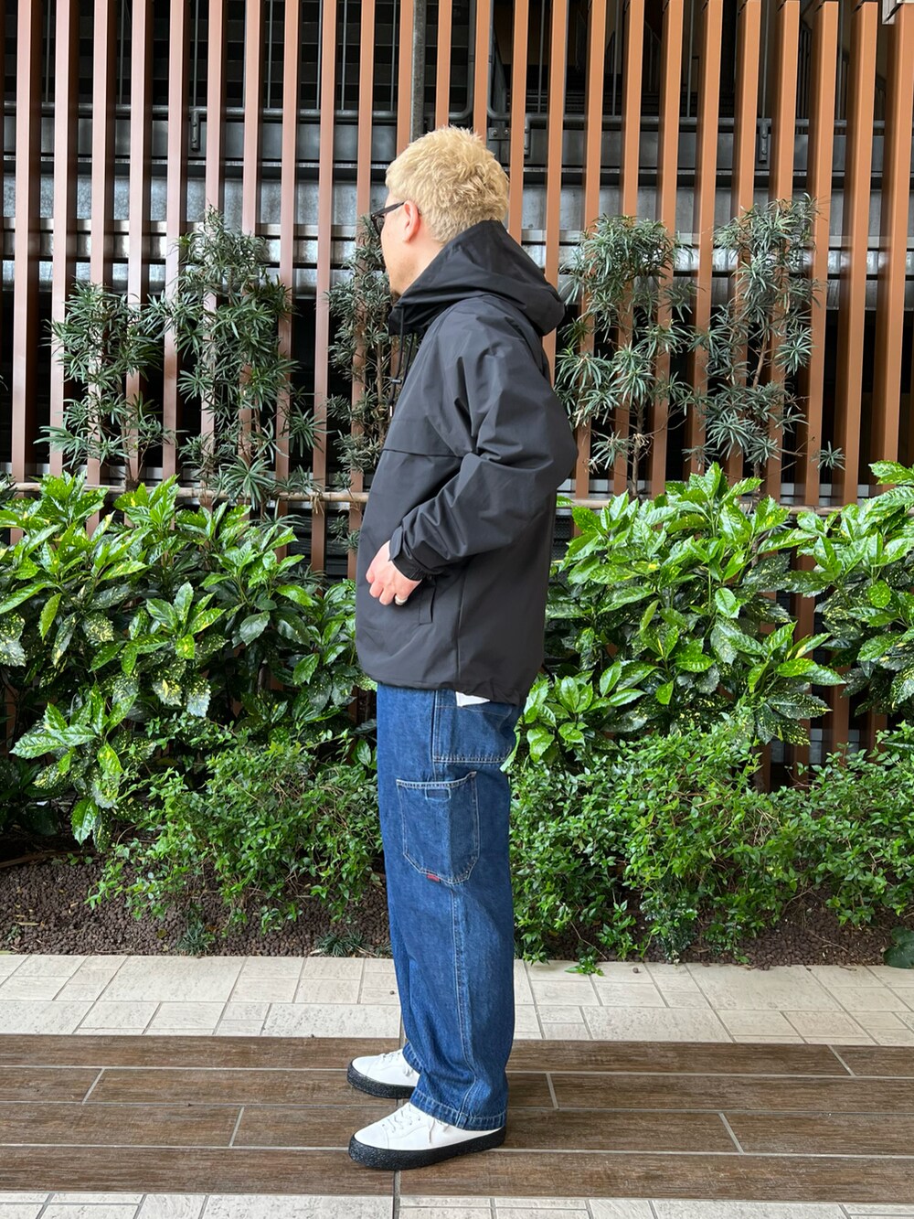 ブラック系のマウンテンパーカー、ブルー系のデニムパンツ、ホワイト系のTシャツ/カットソーを着用したメンズの春コーディネートの4枚目の写真