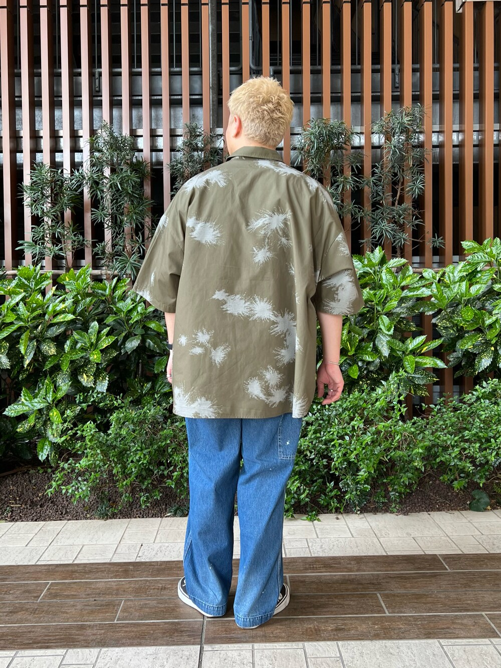 グリーン系のシャツ/ブラウス、ホワイト系のTシャツ/カットソー、ブルー系のデニムパンツを着用したメンズの春コーディネートの4枚目の写真