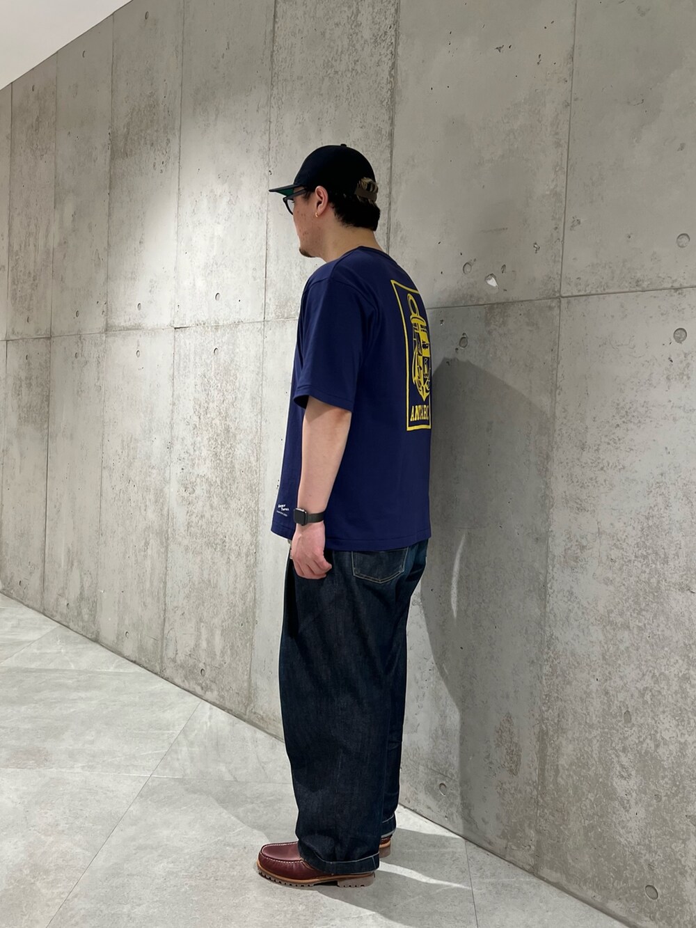 ブルー系のTシャツ/カットソー、ブルー系のデニムパンツ、レッド系のモカシン/デッキシューズを着用したメンズの春コーディネートの3枚目の写真