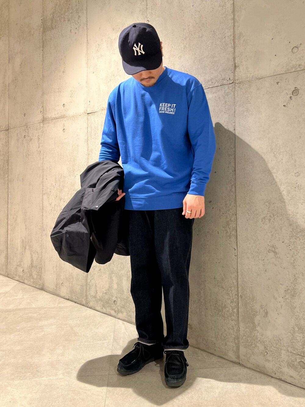 ブラック系のナイロンジャケット、ブルー系のデニムパンツ、ブラック系のブーツを着用したメンズの春コーディネートの5枚目の写真