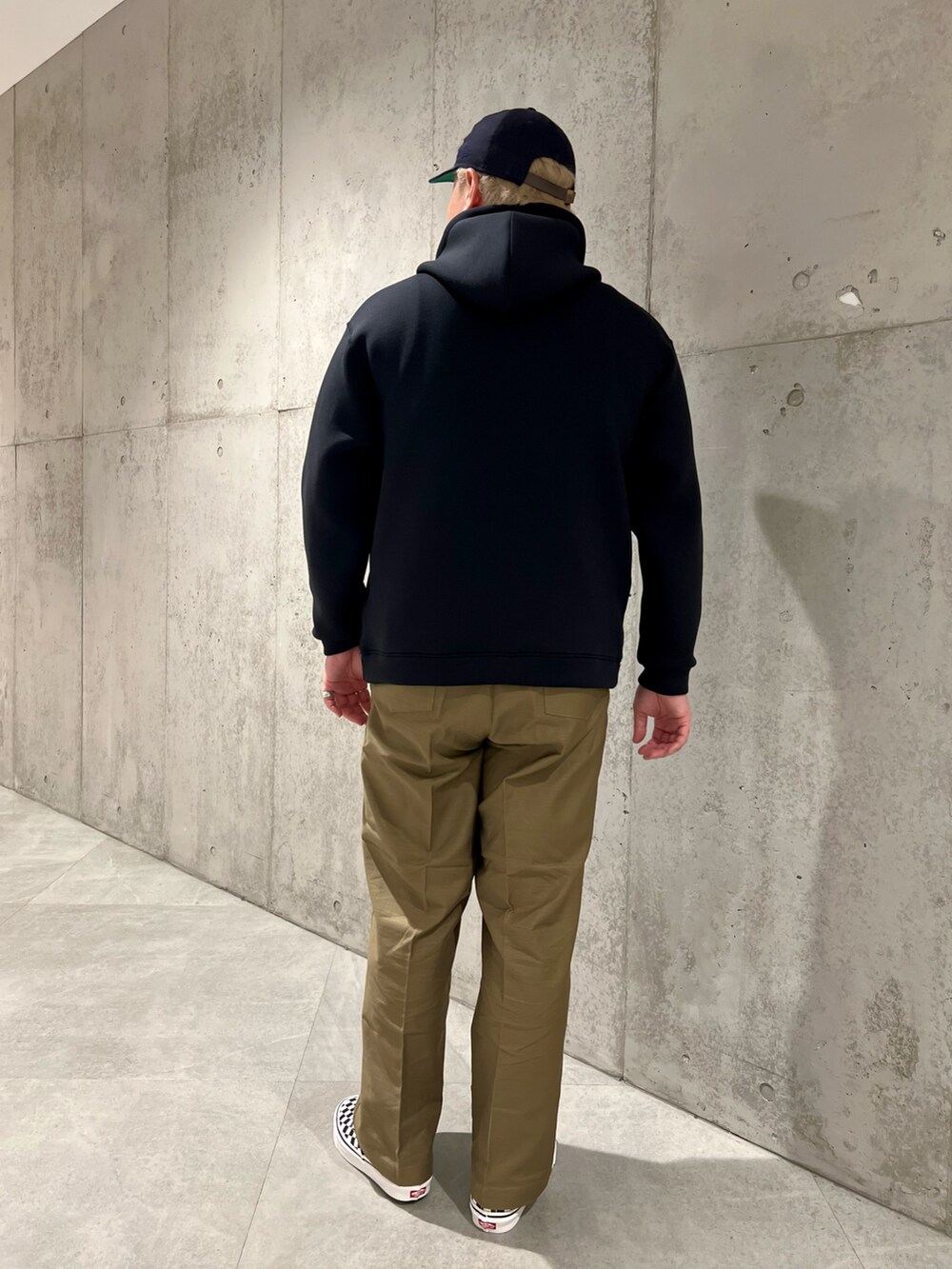 ブラック系のパーカー、グリーン系のその他パンツ、ブラック系のスニーカーを着用したメンズの秋コーディネートの3枚目の写真