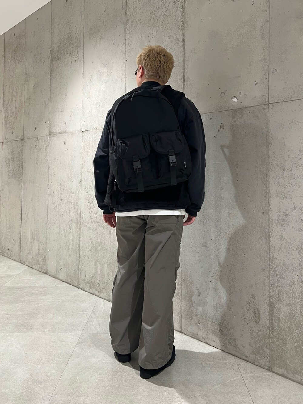 ブラック系のスウェット、ブラック系のその他アウター、ホワイト系のTシャツ/カットソーを着用したメンズの冬コーディネートの3枚目の写真