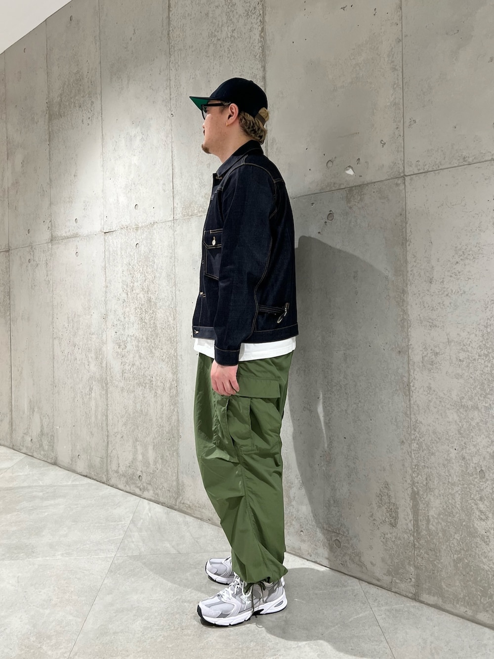 ブルー系のデニムジャケット、ホワイト系のTシャツ/カットソー、グリーン系のカーゴパンツを着用したメンズの春コーディネートの2枚目の写真