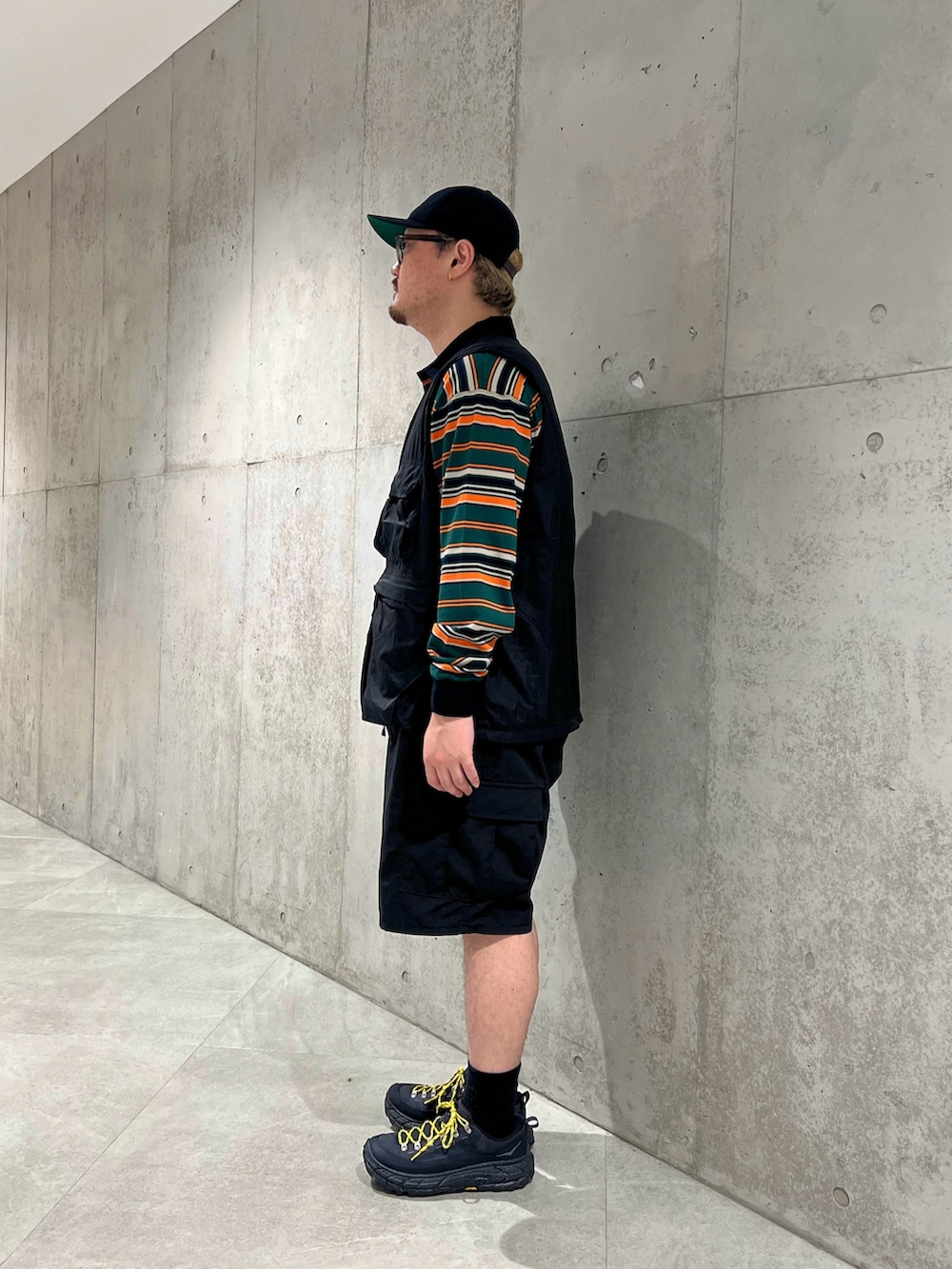 グリーン系のTシャツ/カットソー、ブラック系のベスト、ブラック系のその他パンツを着用したメンズの夏コーディネートの3枚目の写真