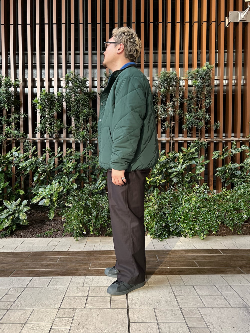 グリーン系のブルゾン、ホワイト系のTシャツ/カットソー、ブラック系のその他パンツを着用したメンズの冬コーディネートの2枚目の写真