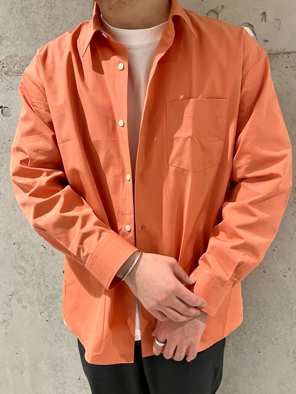 オレンジ系のシャツ/ブラウス、その他のスリッポン、ホワイト系のTシャツ/カットソーを着用したメンズの冬コーディネートの4枚目の写真