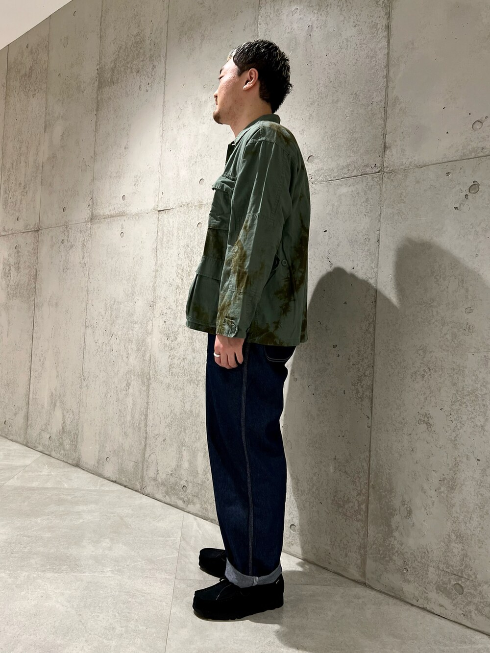 ブルー系のデニムパンツ、ブラック系のブーツ、ブルー系のミリタリージャケットを着用したメンズの春コーディネートの3枚目の写真