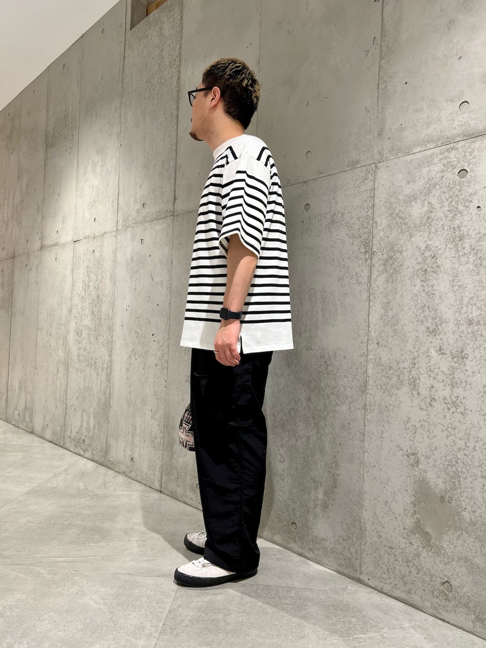 ブラック系のショルダーバッグ、ホワイト系のスニーカー、ブラック系のその他パンツを着用したメンズの夏コーディネートの3枚目の写真