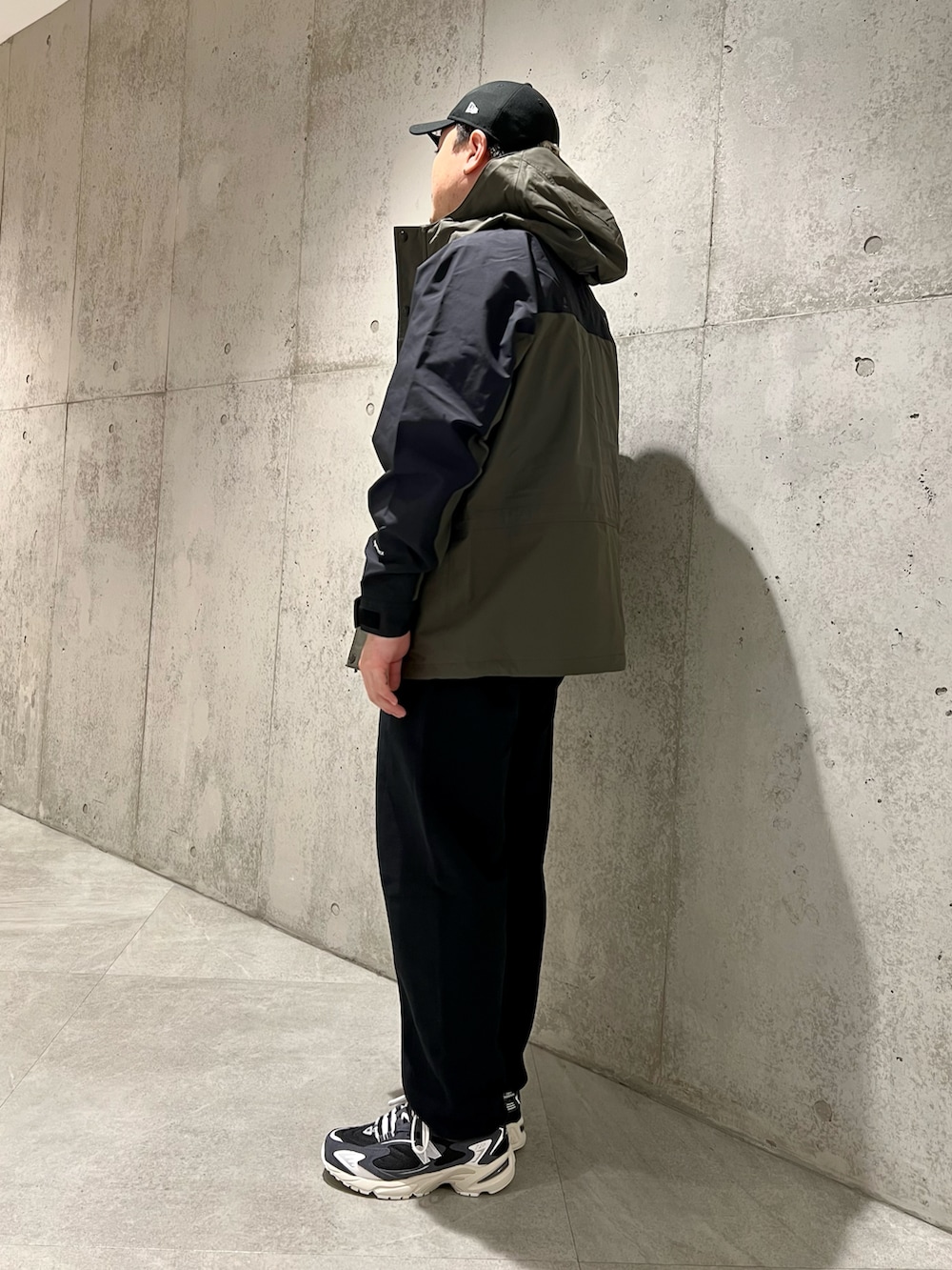 グリーン系のナイロンジャケット、ブラック系のスニーカー、ブラック系のスウェットパンツを着用したメンズの春コーディネートの3枚目の写真