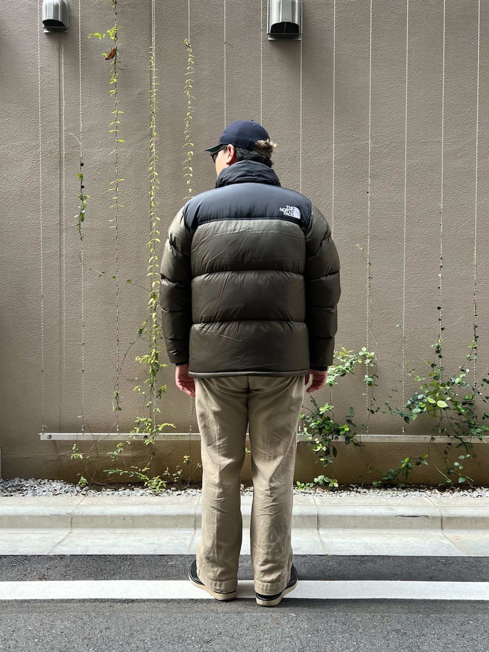 グリーン系のダウンジャケット/コート、ブラック系のブーツを着用したメンズの秋コーディネートの3枚目の写真