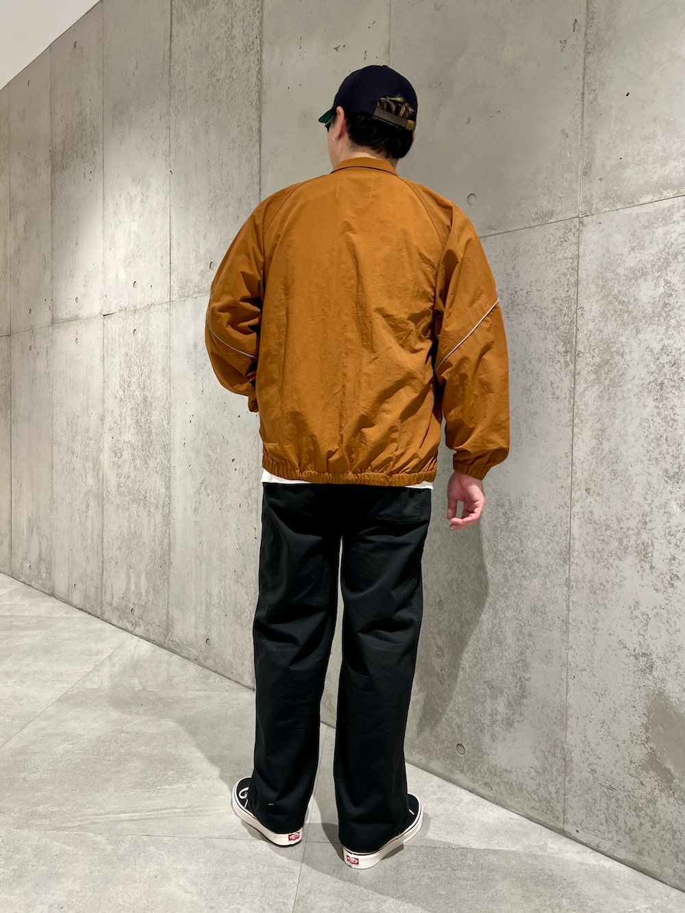 ホワイト系のTシャツ/カットソー、ブラック系のチノパンツ、ブラウン系のブルゾンを着用したメンズの秋コーディネートの4枚目の写真