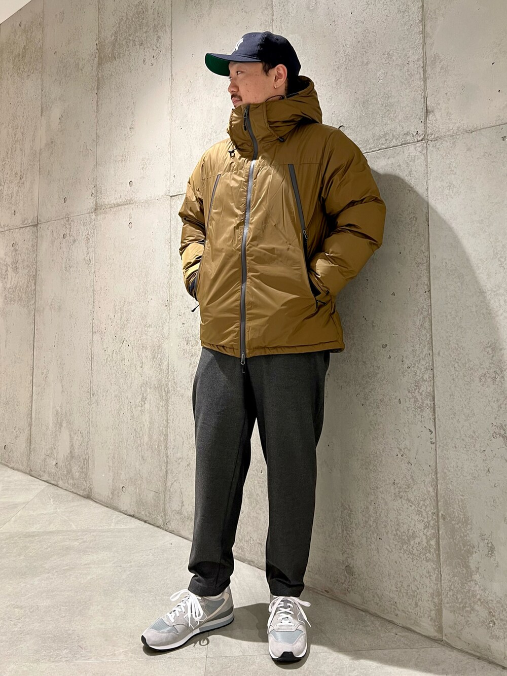 ベージュ系のダウンジャケット/コート、ブラウン系のニット/セーター、グレー系のその他パンツを着用したメンズの冬コーディネートの4枚目の写真