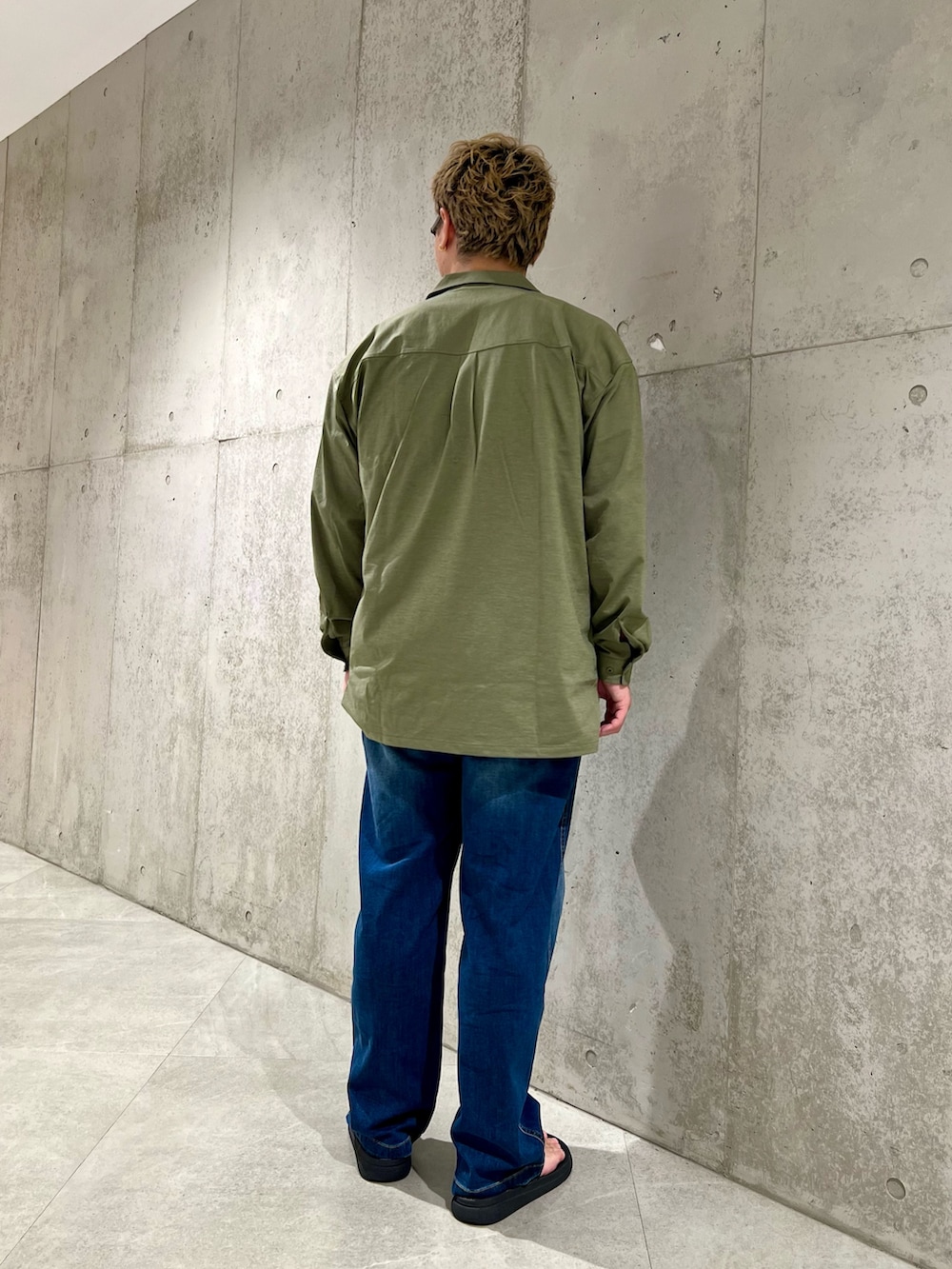 グリーン系のシャツ/ブラウス、ブルー系のデニムパンツ、ブラック系のサンダルを着用したメンズの夏コーディネートの3枚目の写真