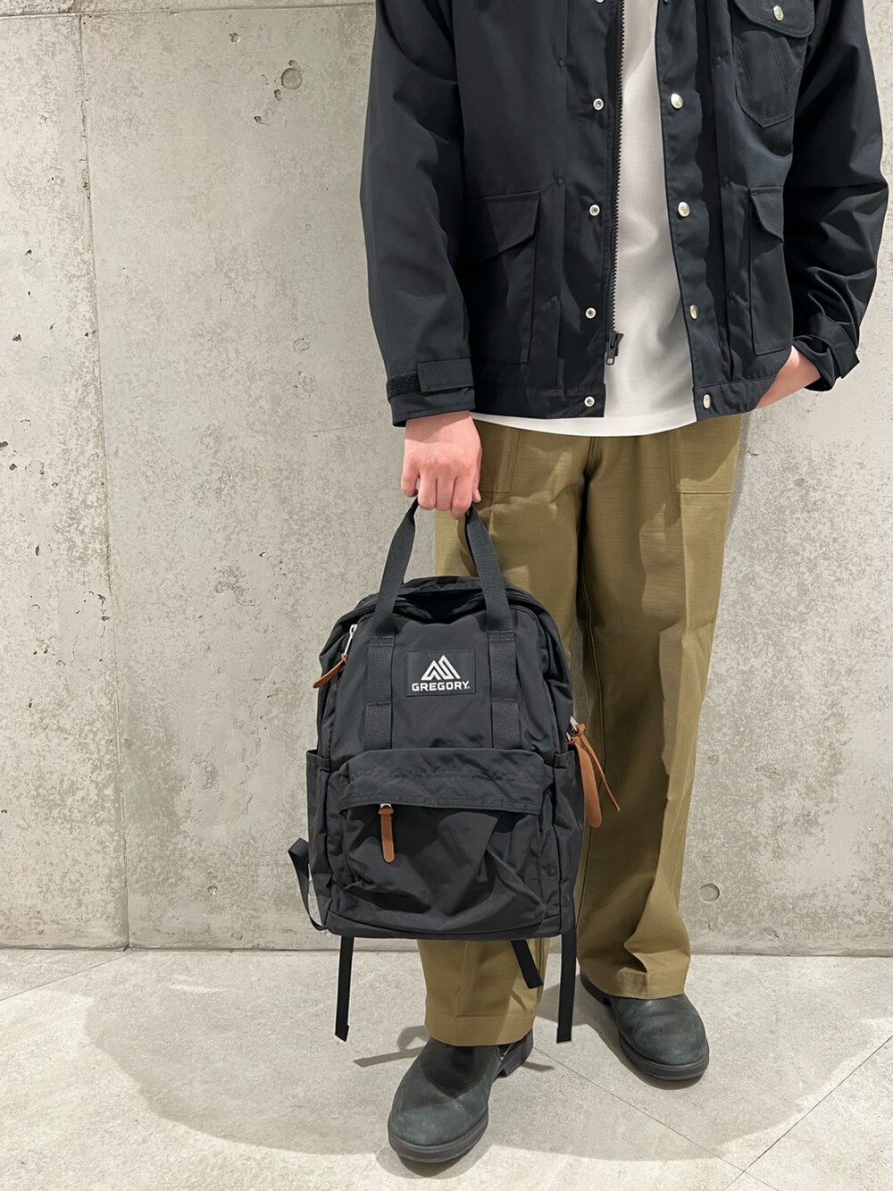 ブラック系のその他アウター、ホワイト系のTシャツ/カットソー、ブラック系のバックパック/リュックを着用したメンズの秋コーディネートの3枚目の写真