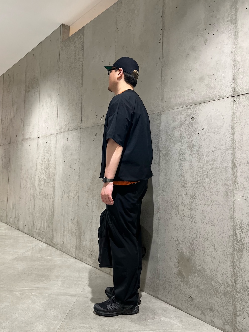 ブラック系のTシャツ/カットソー、オレンジ系のTシャツ/カットソー、ブラック系のその他パンツを着用したメンズの春コーディネートの2枚目の写真