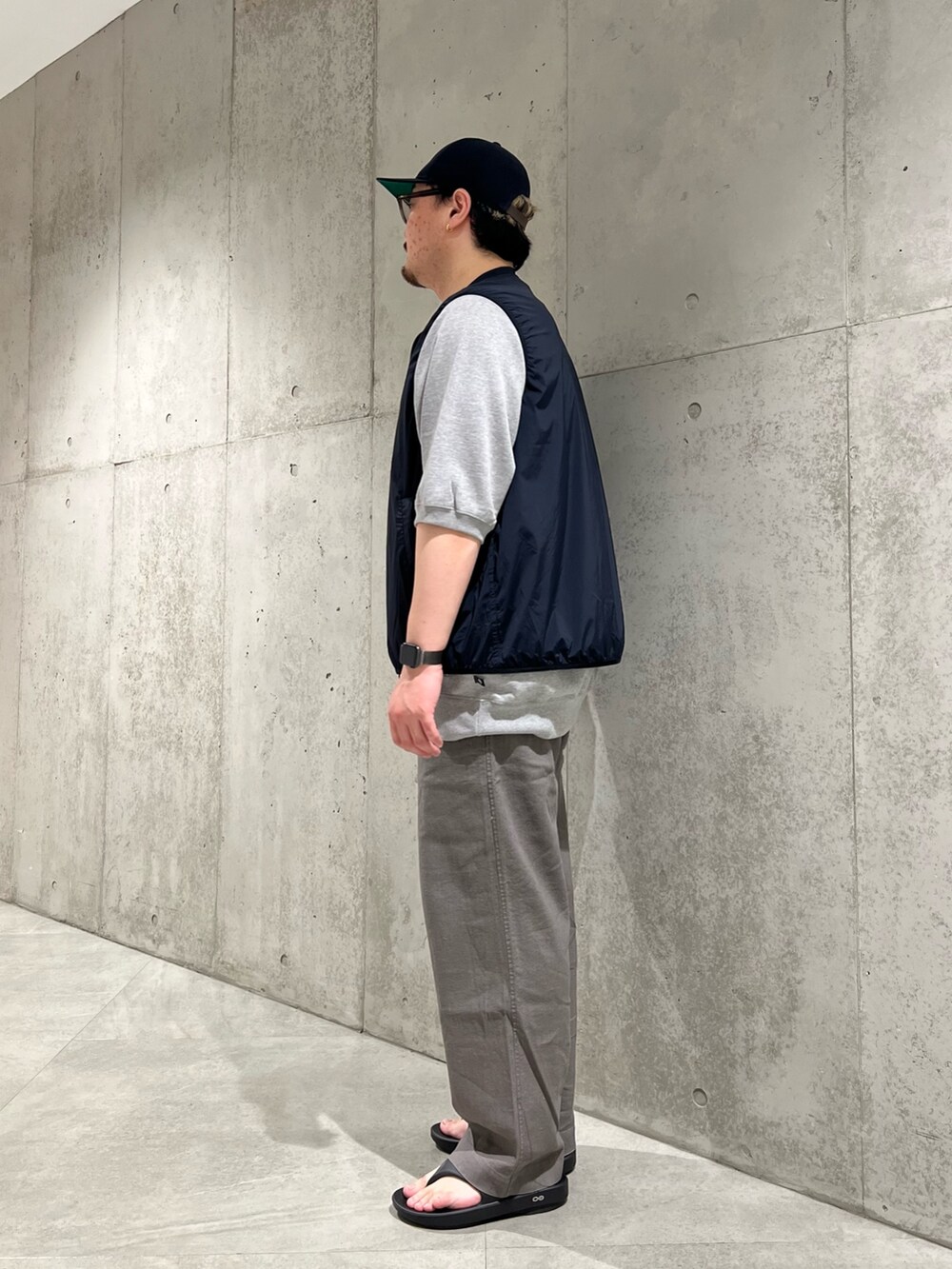 ブラック系のベスト、グレー系のその他パンツ、ブラック系のサンダルを着用したメンズの夏コーディネートの2枚目の写真