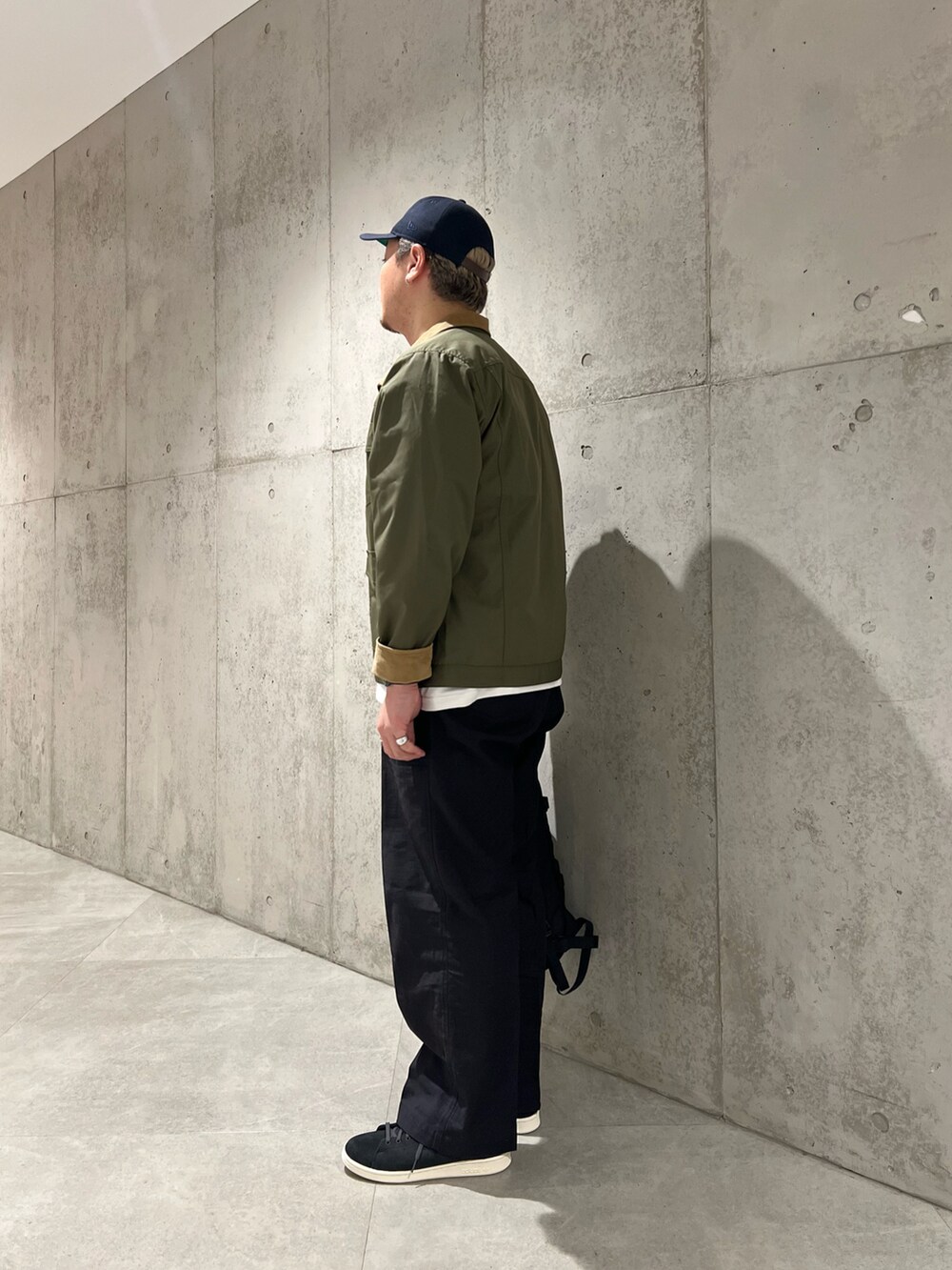 ブラック系のその他アウター、ホワイト系のTシャツ/カットソー、ブラック系のその他パンツを着用したメンズの秋コーディネートの2枚目の写真