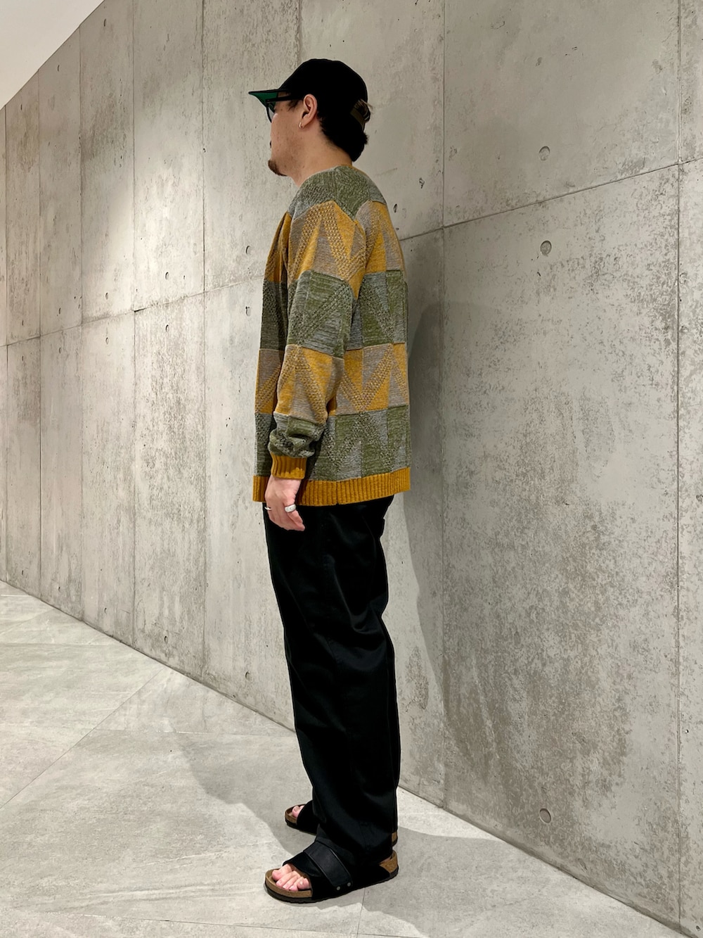 ホワイト系のTシャツ/カットソー、ブラック系のチノパンツ、イエロー系のカーディガン/ボレロを着用したメンズの夏コーディネートの3枚目の写真