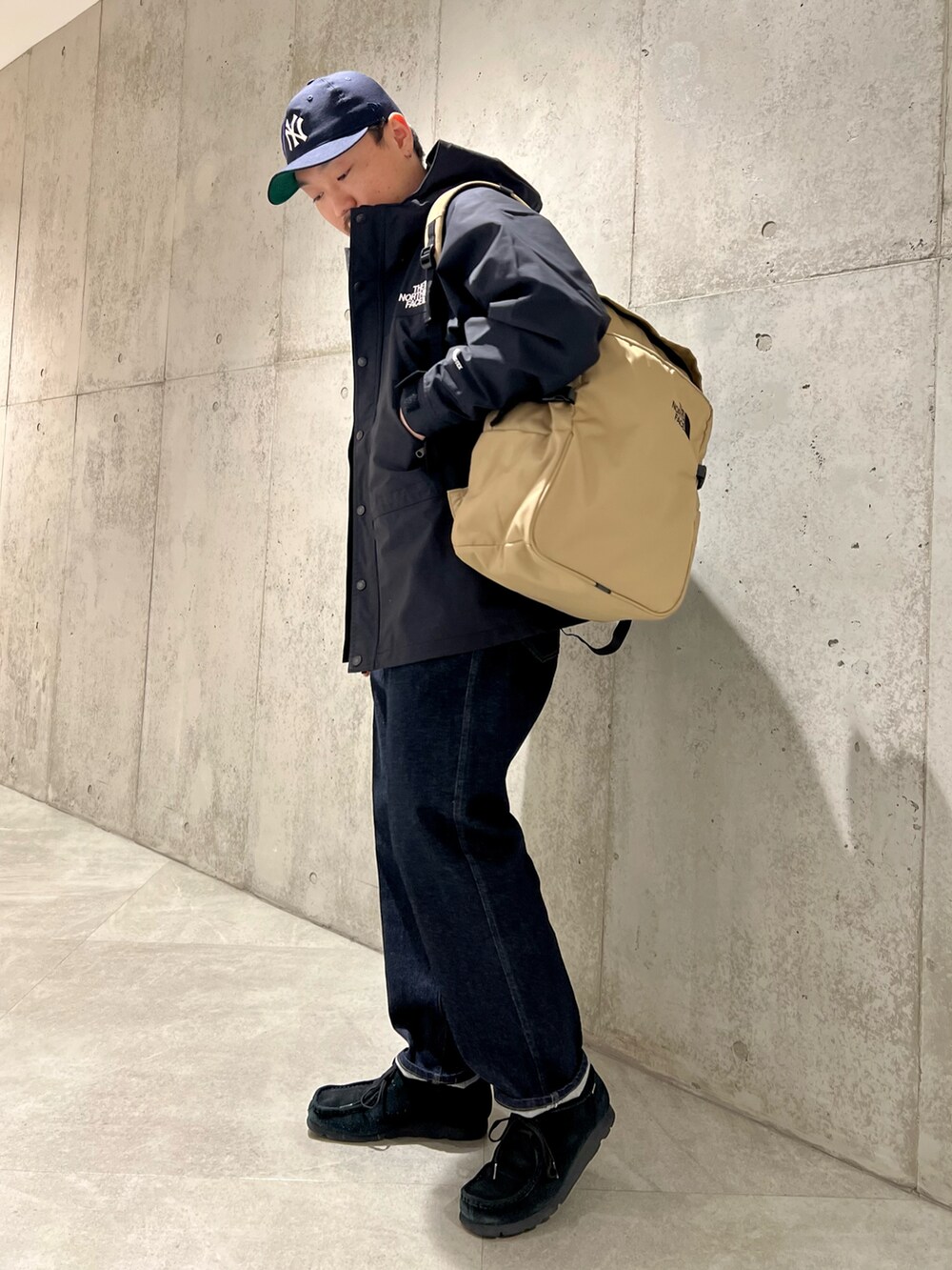 ブラック系のナイロンジャケット、ブルー系のデニムパンツ、ブラック系のブーツを着用したメンズの春コーディネートの3枚目の写真