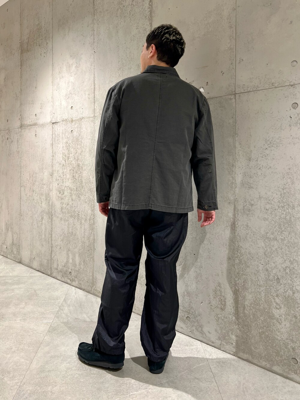 ブラック系のカバーオール、ホワイト系のTシャツ/カットソー、ブラック系のブーツを着用したメンズの春コーディネートの4枚目の写真