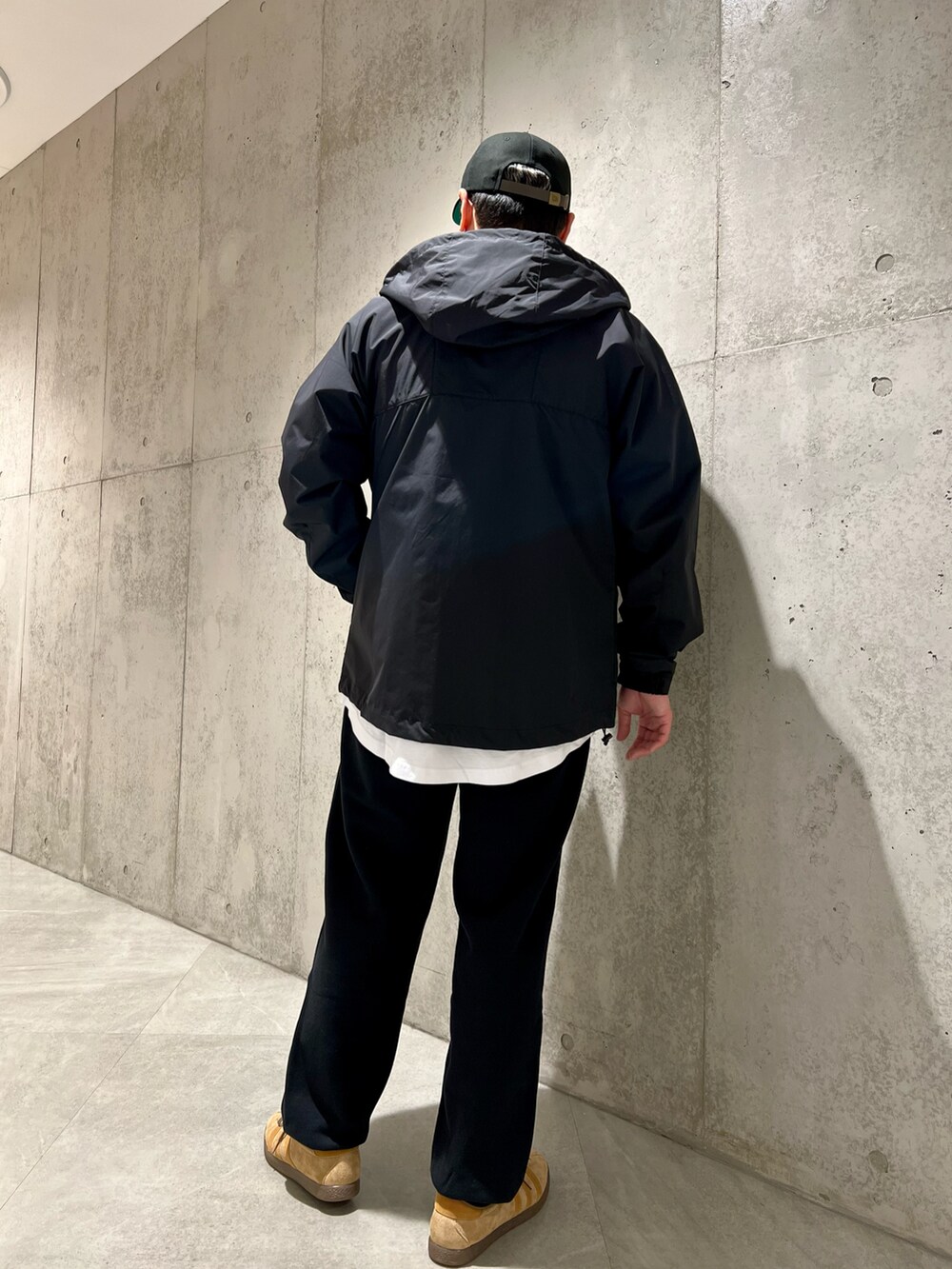 ブラック系のマウンテンパーカー、ブラック系のスウェットパンツ、レッド系のTシャツ/カットソーを着用したメンズの春コーディネートの5枚目の写真