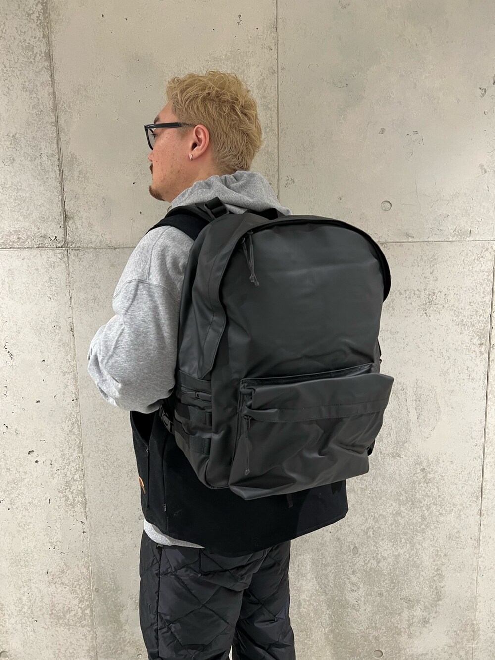 グレー系のパーカー、ブラック系のその他パンツ、ブラック系のバックパック/リュックを着用したメンズの冬コーディネートの4枚目の写真