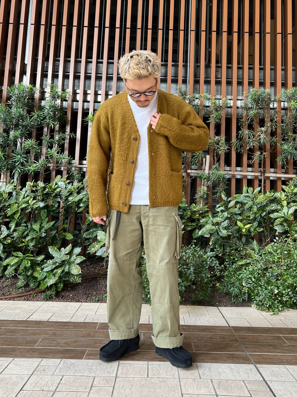 グリーン系のカーゴパンツ、ブラック系のブーツ、ホワイト系のTシャツ/カットソーを着用したメンズの秋コーディネートの2枚目の写真